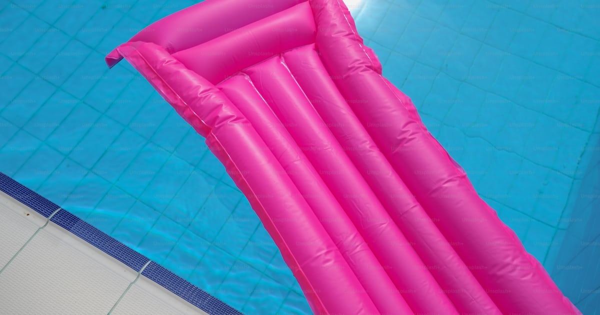 A large pink inflatable pool float in a swimming pool photo – Float ...