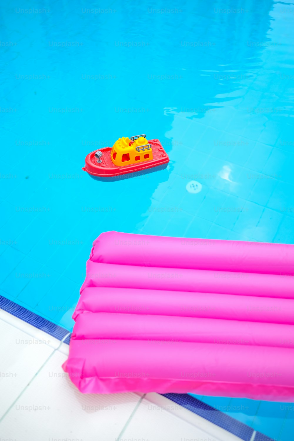 an inflatable raft sitting next to a swimming pool