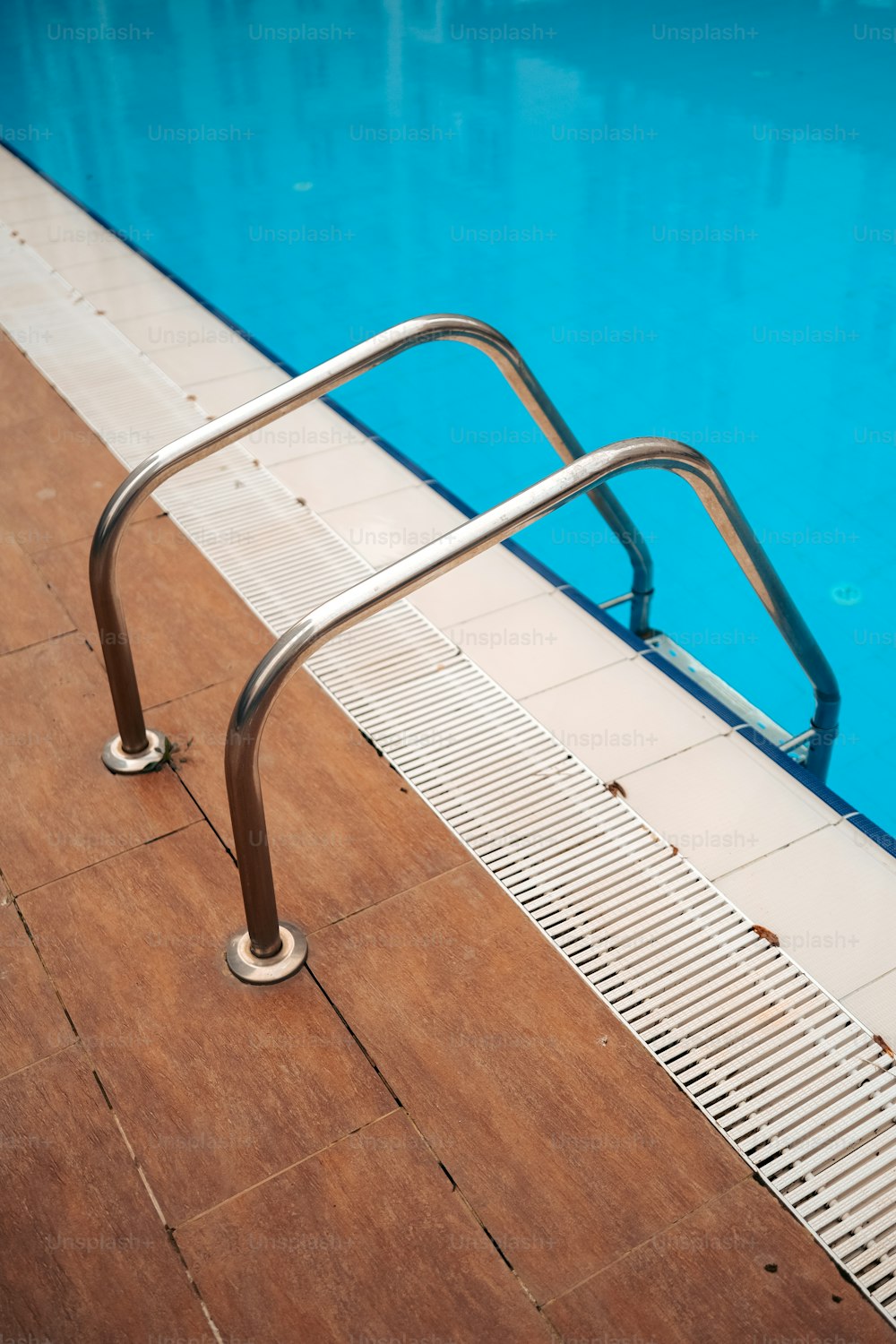 um corrimão de metal ao lado de uma piscina