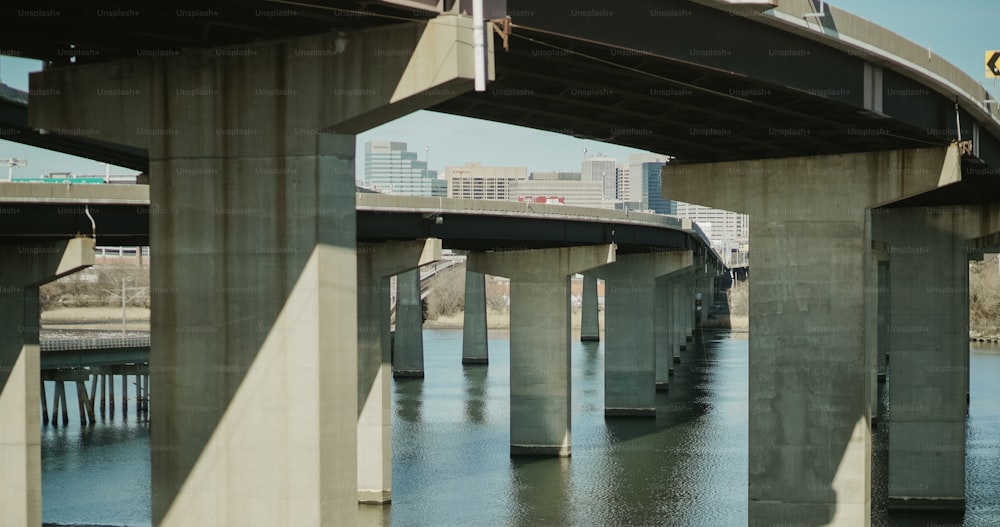 uma ponte sobre um corpo de água com edifícios altos ao fundo
