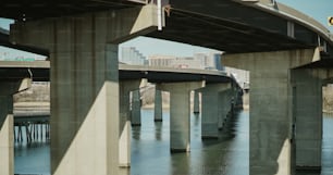 a bridge over a body of water with tall buildings in the background