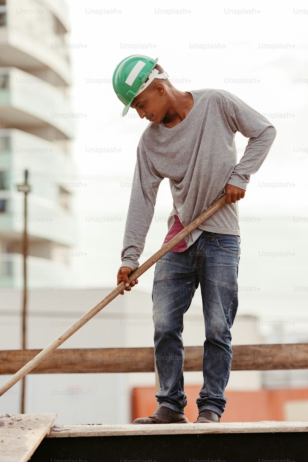 a man in a hard hat is holding a long pole