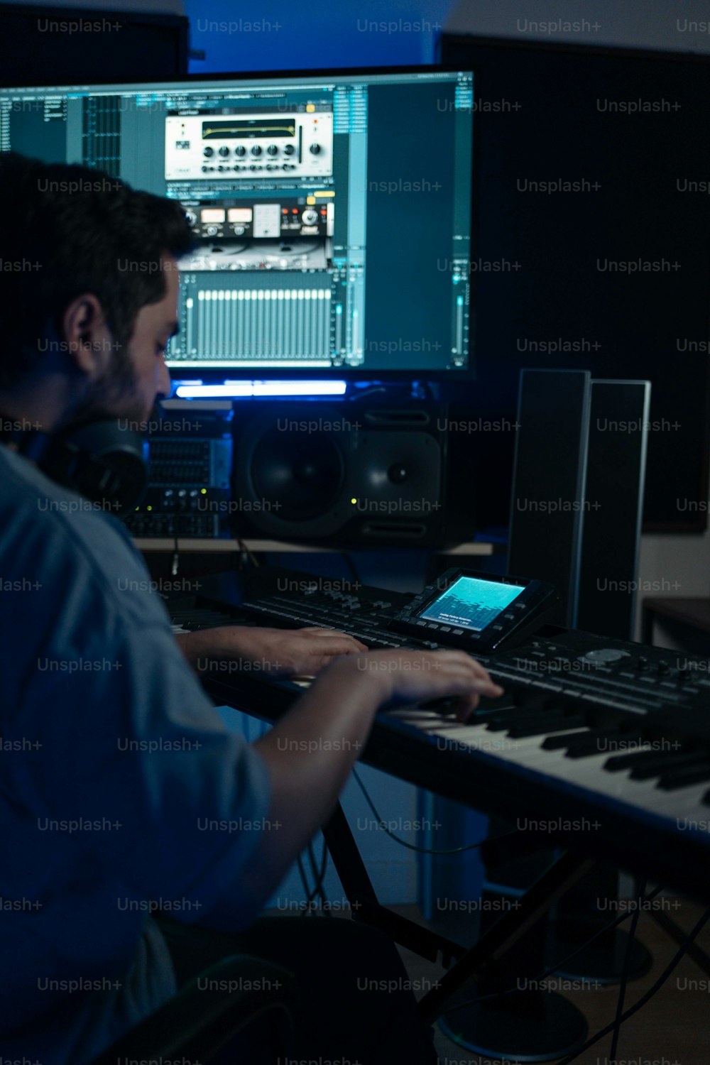 a man sitting at a keyboard in front of a monitor