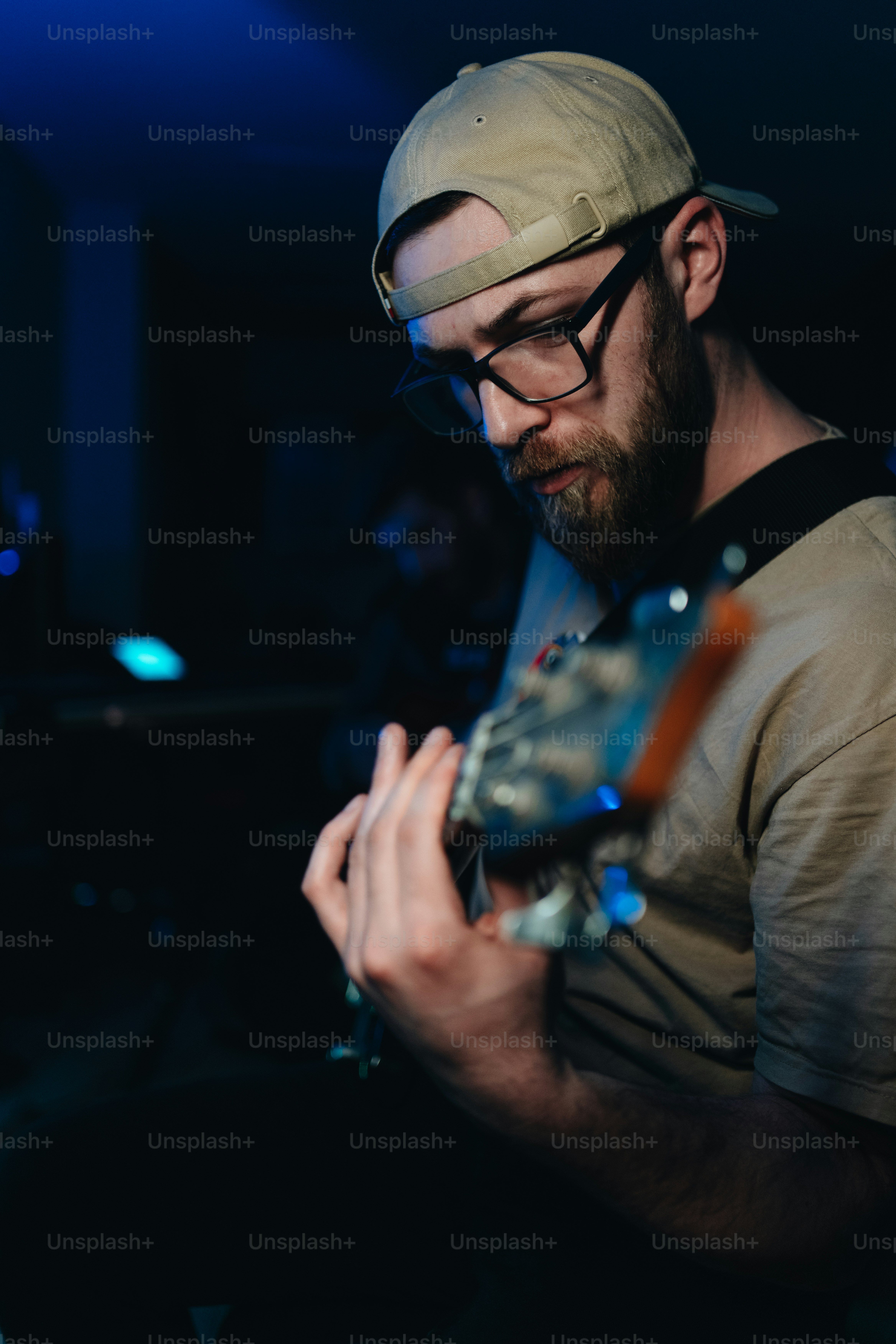 Un homme jouant de la guitare dans une pièce sombre