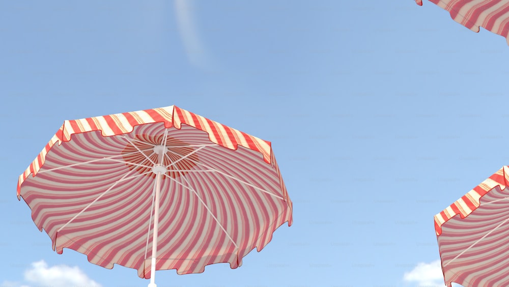a group of pink and white striped umbrellas
