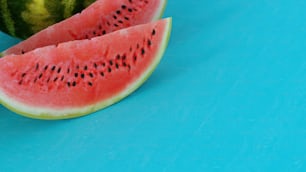 two pieces of watermelon on a blue surface
