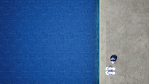 a person laying on the ground next to a swimming pool