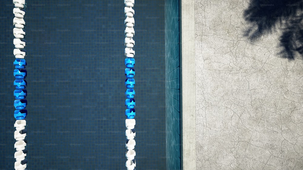uma vista aérea de uma piscina com azulejos azuis e brancos