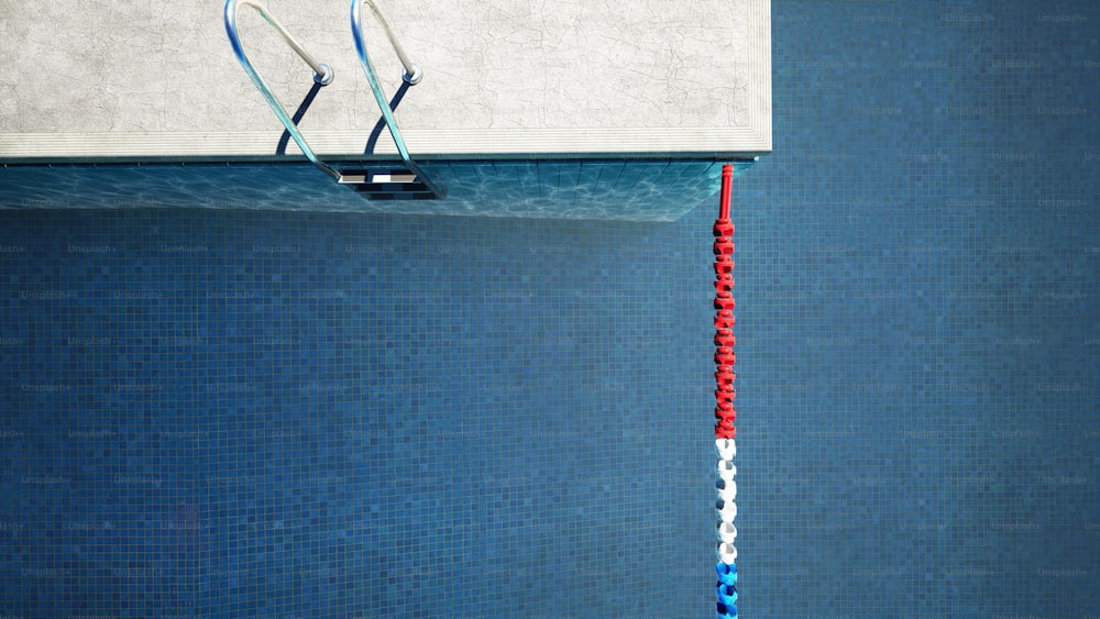 un poteau rouge, blanc et bleu sortant d’une piscine