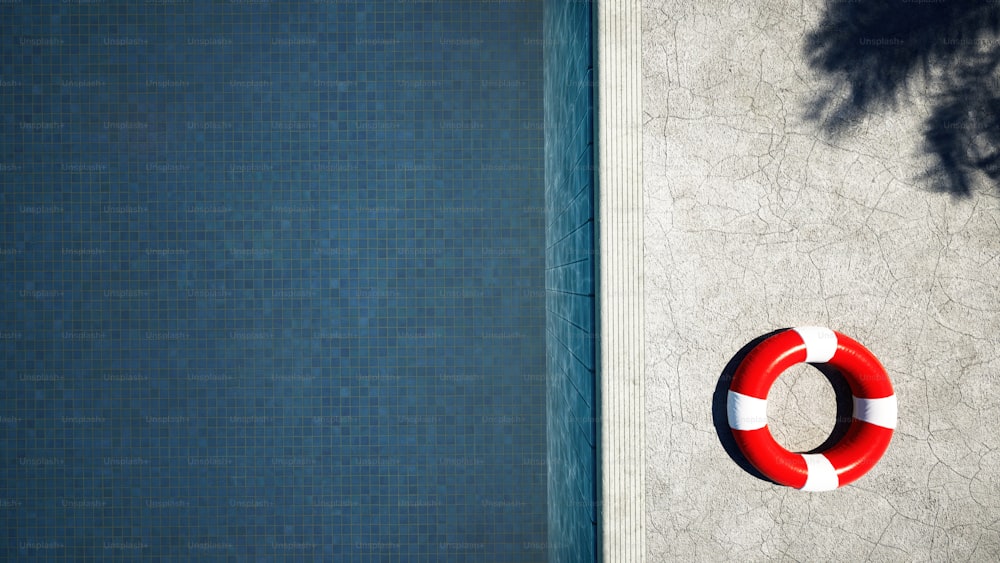 a red and white life preserver next to a swimming pool