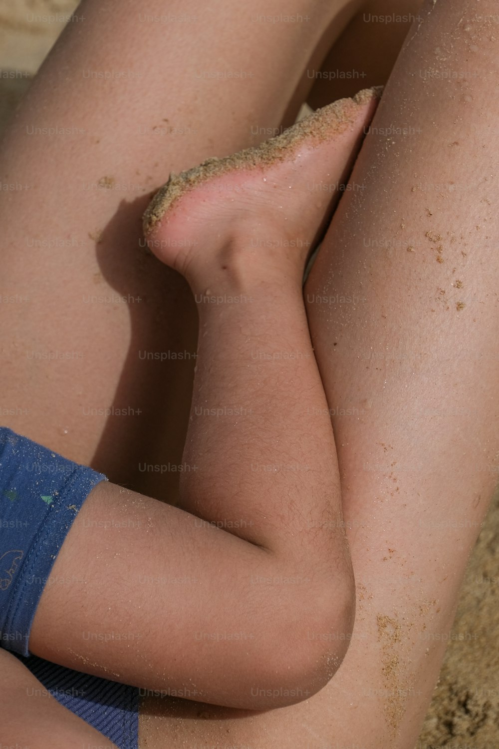 a close up of a person laying on the sand