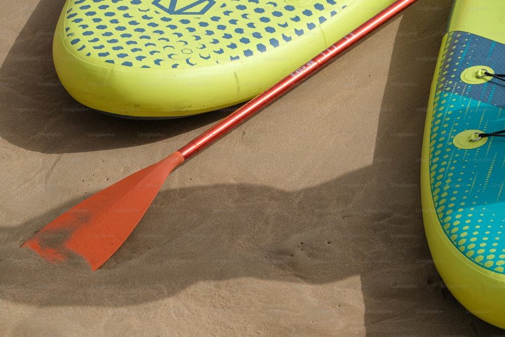 un kayak et une pagaie posés sur le sable