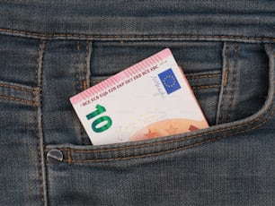 a euro bill sticking out of the back pocket of a pair of jeans