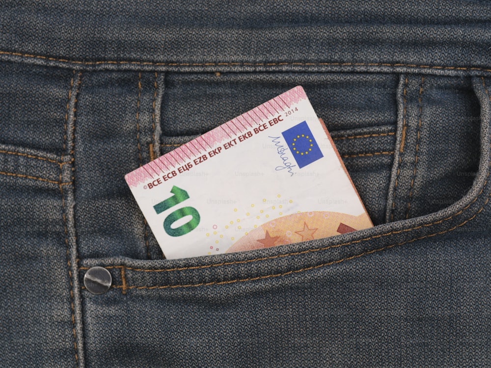 Un billete de euro que sobresale del bolsillo trasero de un par de jeans