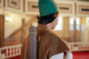 a man wearing a green hat and a brown coat