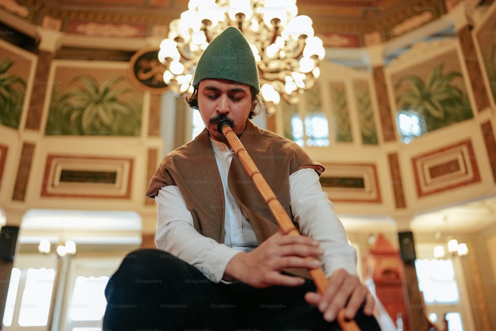 a man in a green hat playing a flute