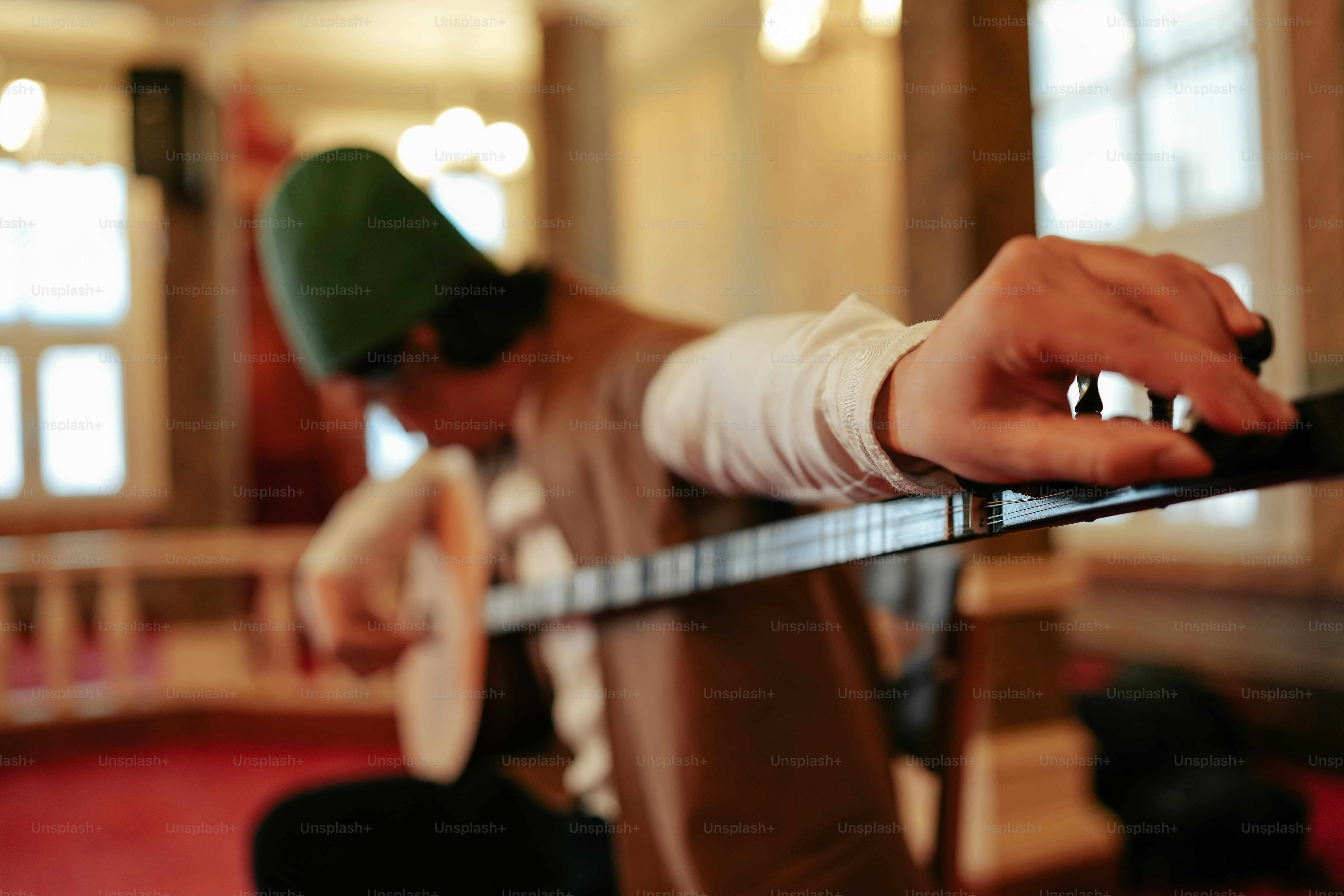 a man with a green hat playing a guitar