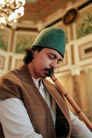 a man wearing a green hat and holding a pipe