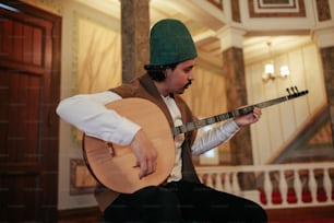 a man in a green hat playing a guitar