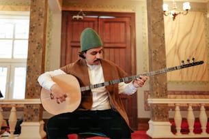a man sitting on a chair playing a guitar