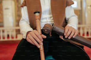 a person sitting on a chair holding a cane