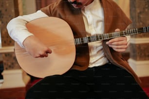 Ein Mann in Weste, der Gitarre spielt