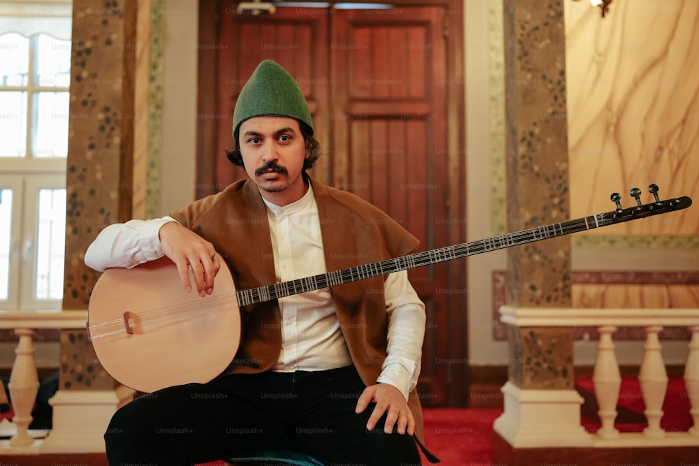 a man sitting on a chair holding a guitar