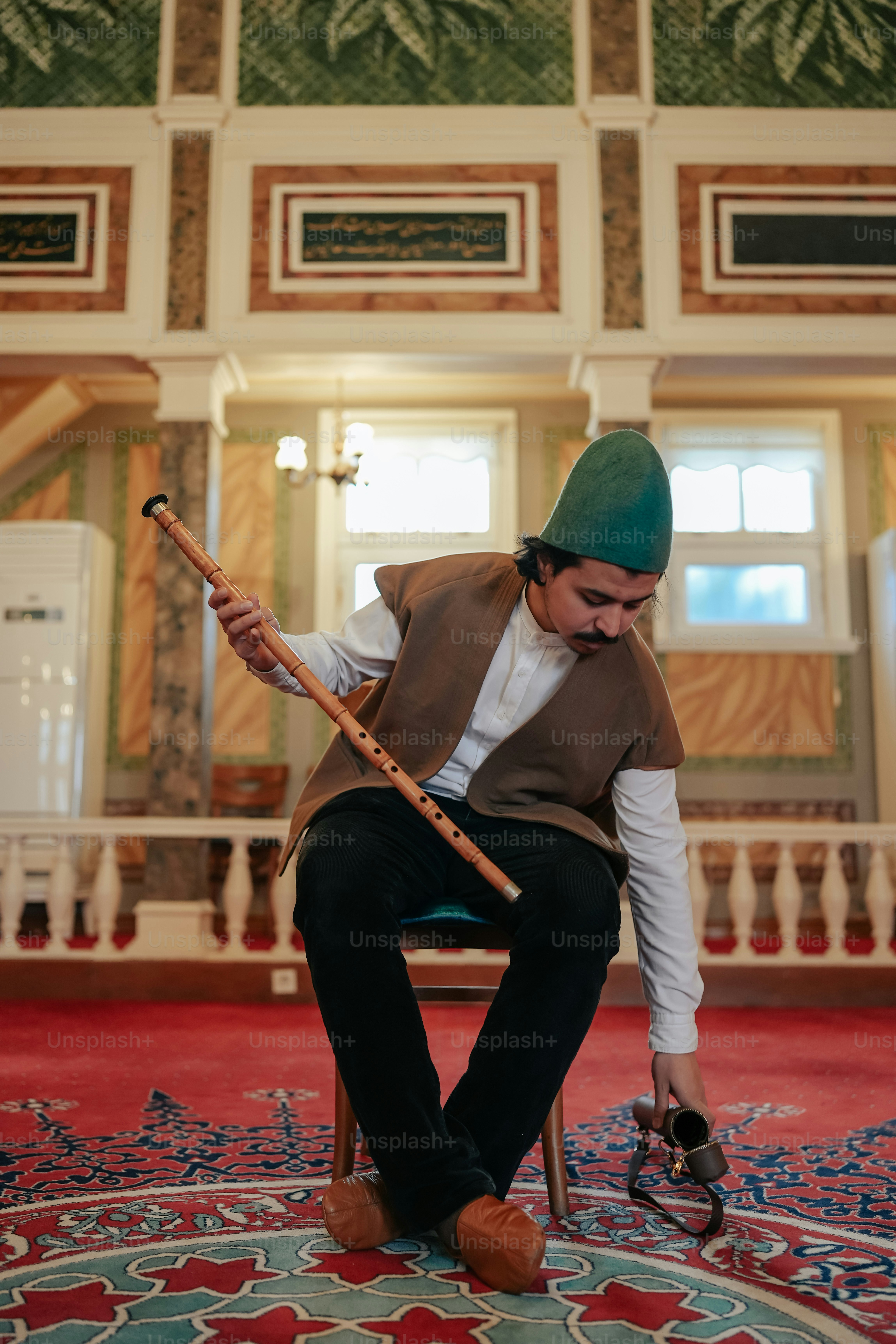 a man sitting on a chair holding a stick