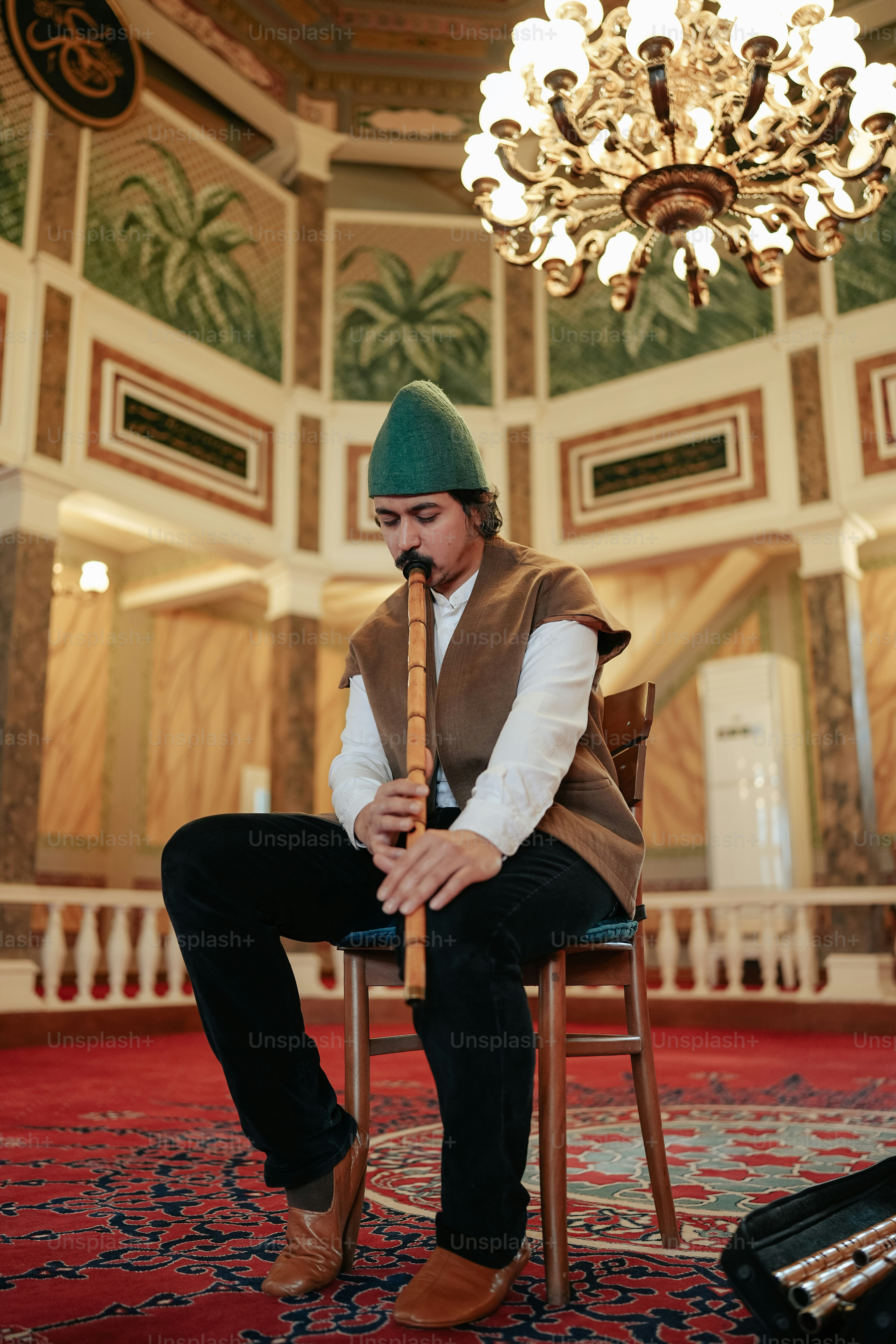 Un hombre sentado en una silla con una pipa en la boca
