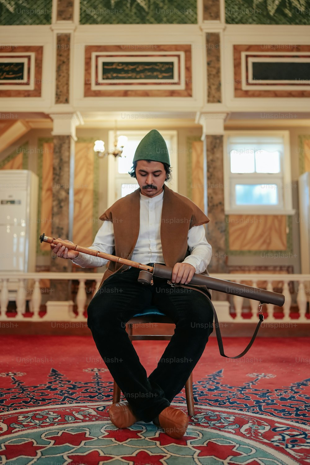 a man sitting on a chair holding a rifle