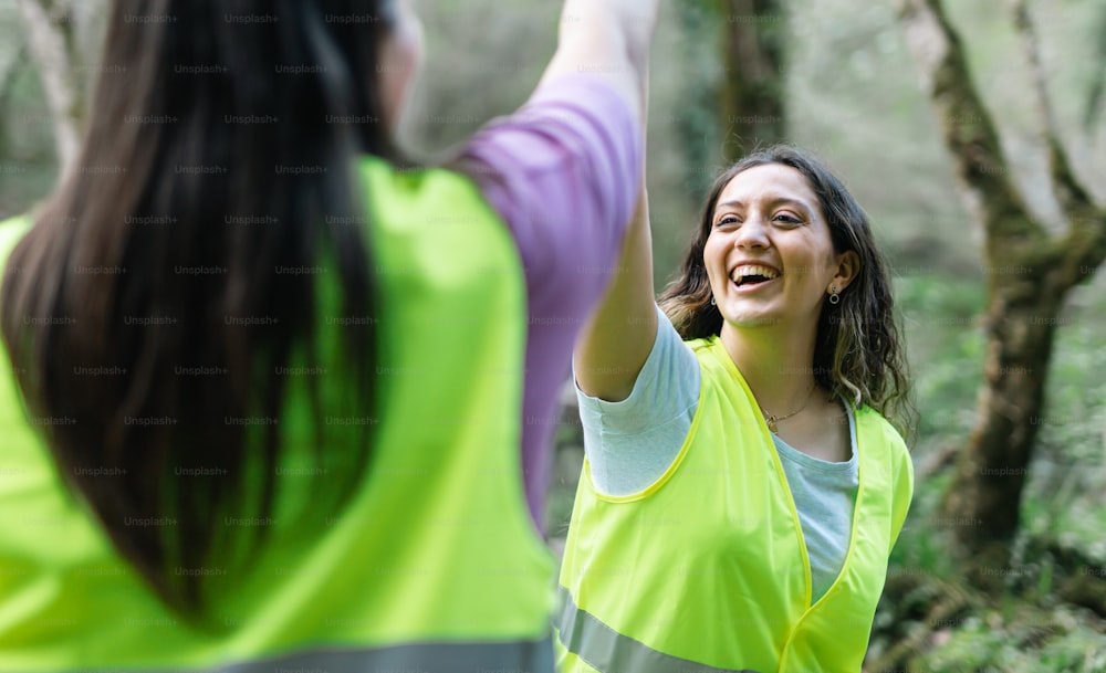 a woman in a yellow vest is throwing a frisbee