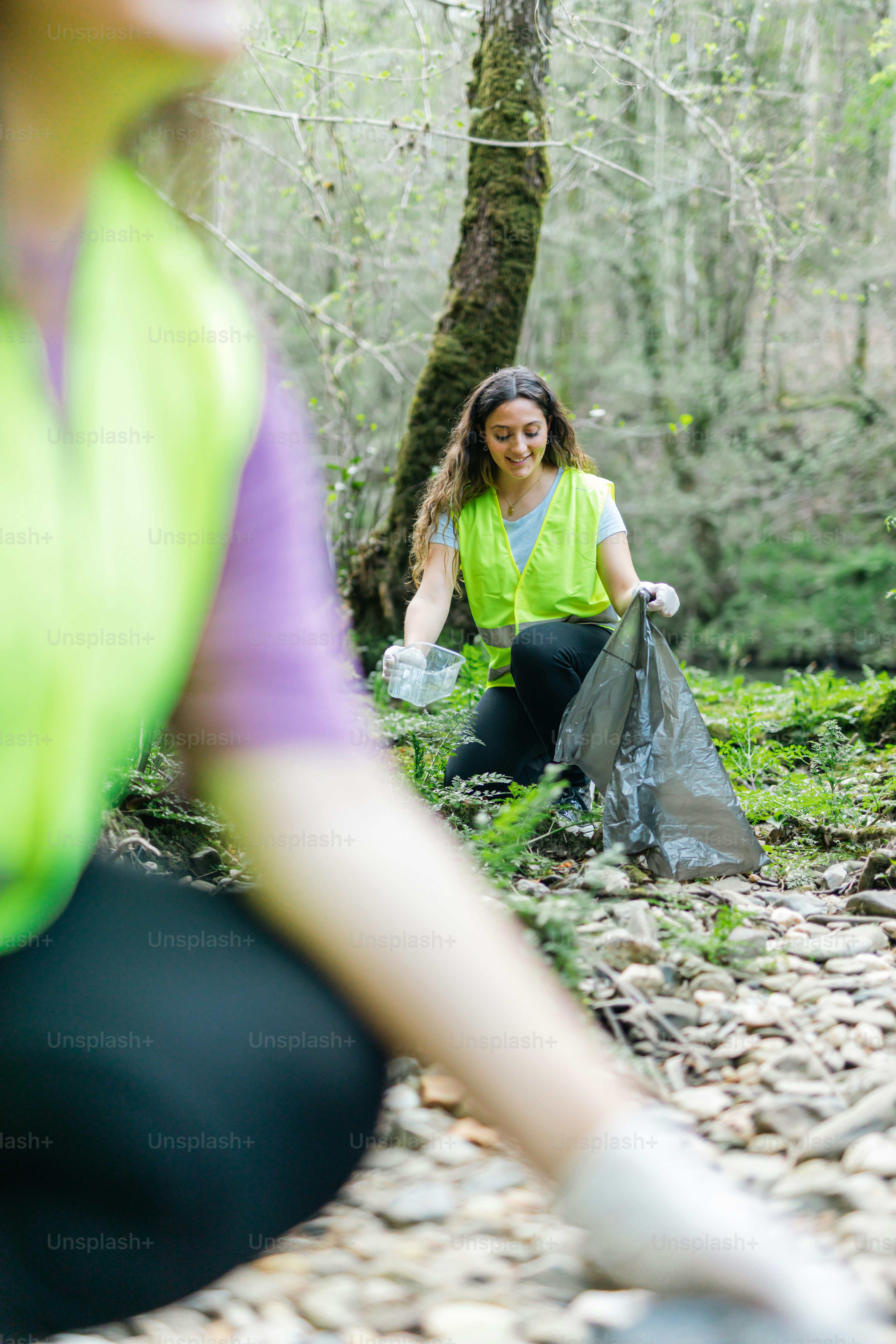 a woman sitting on the ground in the woods