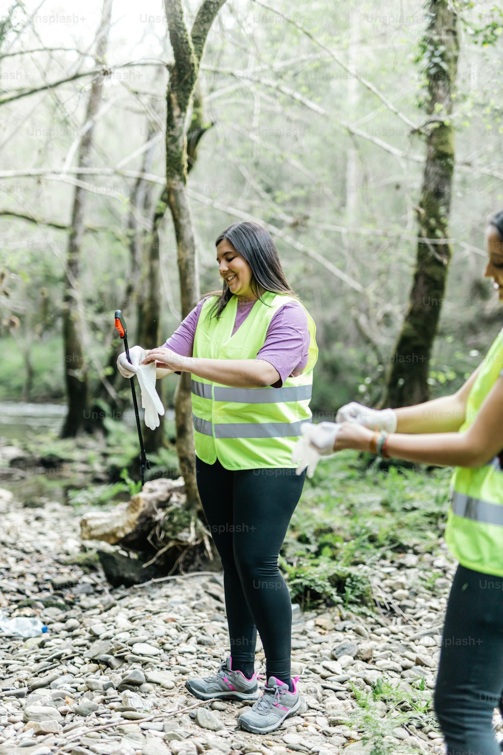 a couple of women standing next to each other in a forest