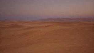 um deserto com dunas de areia e montanhas à distância
