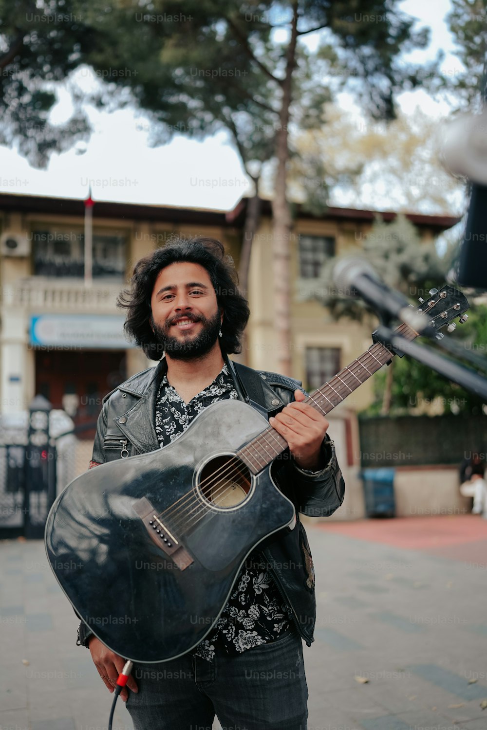 a man holding a guitar on a city street