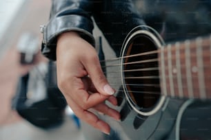 um close up de uma pessoa tocando uma guitarra
