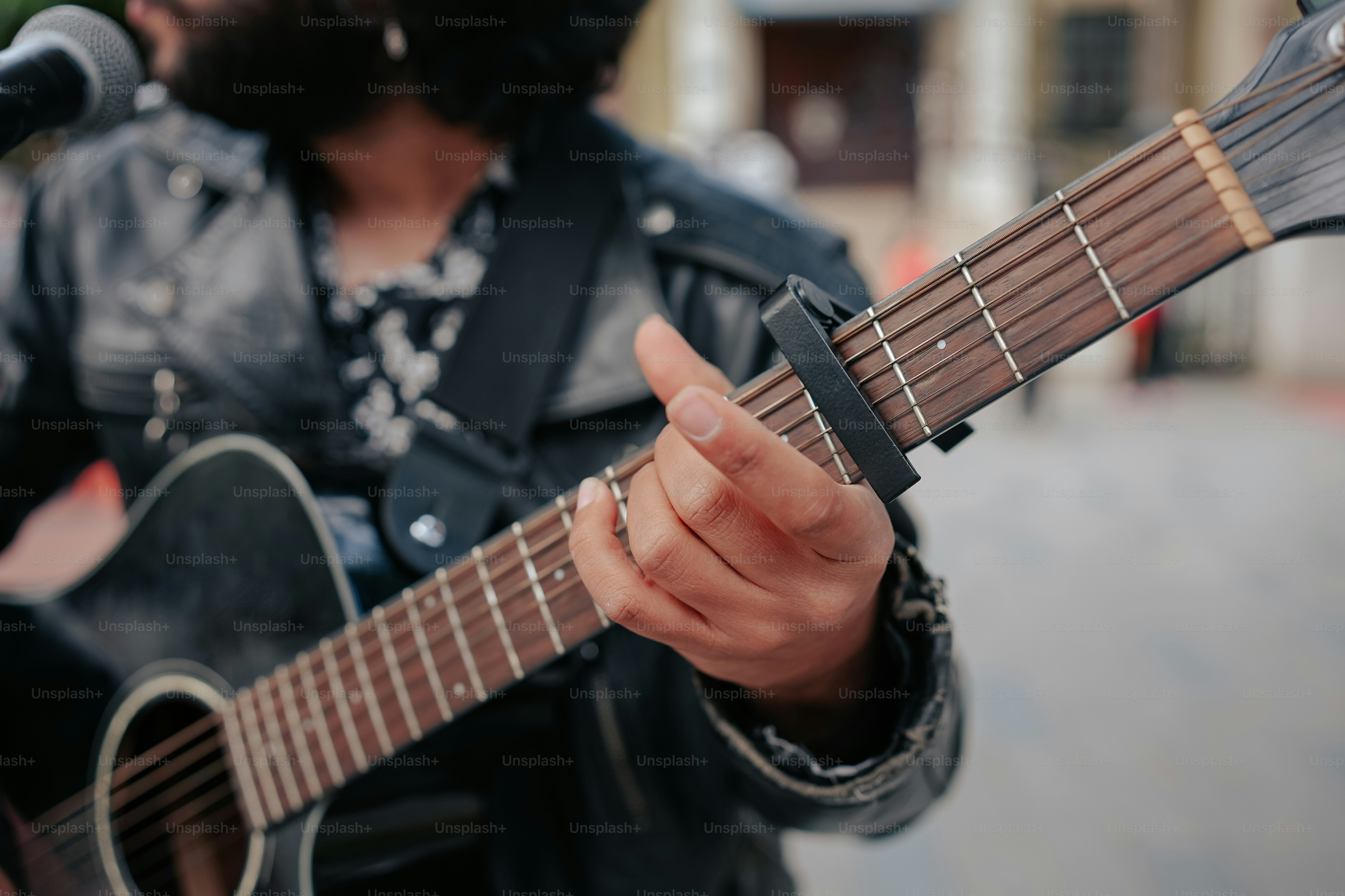 a man holding a guitar and singing into a microphone