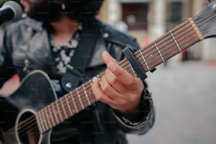 Un hombre sosteniendo una guitarra y cantando en un micrófono