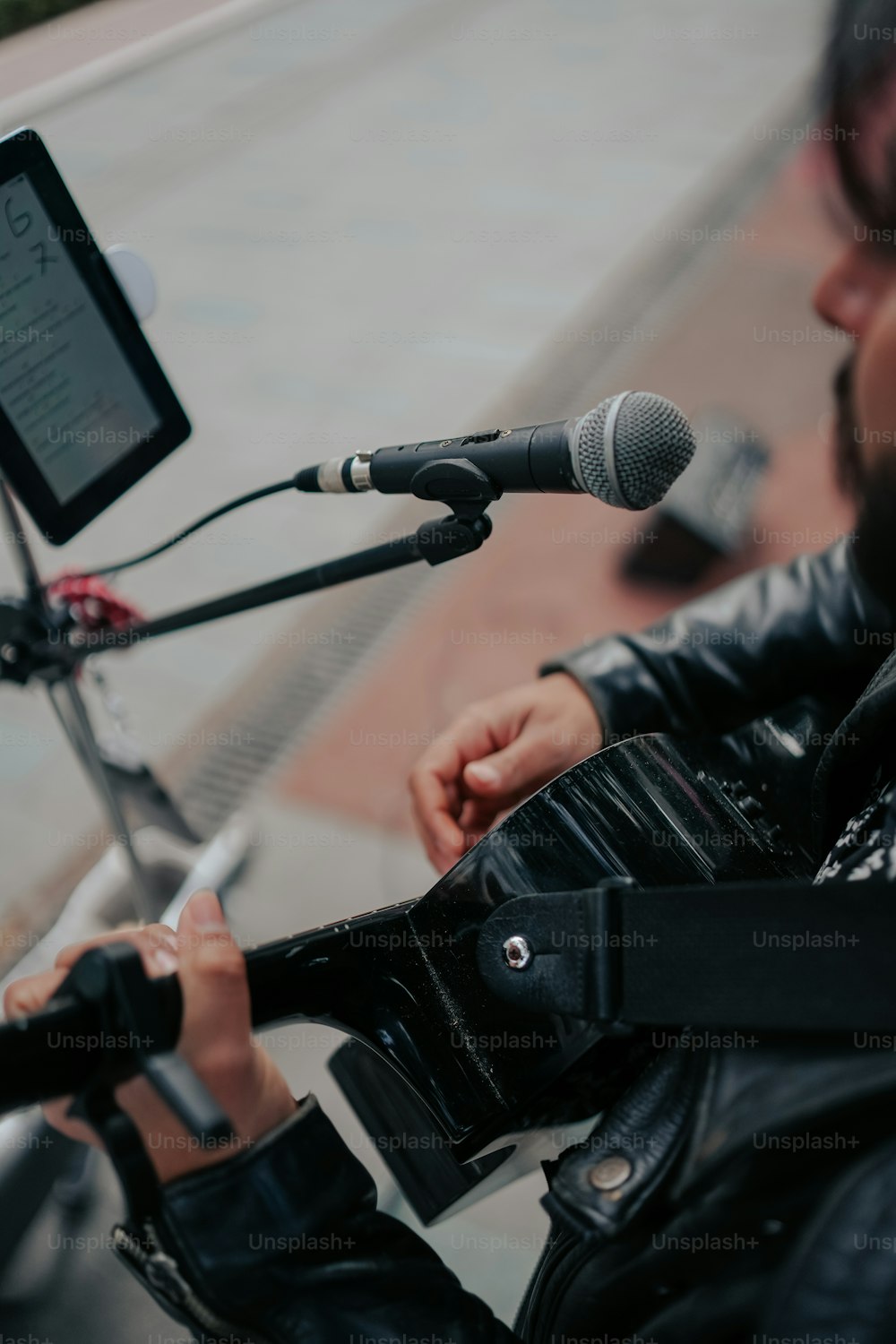 um homem em uma jaqueta de couro segurando um microfone