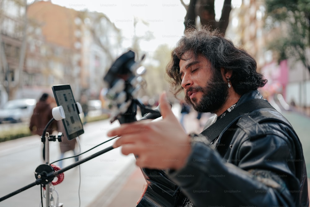 a man standing next to a street holding a cell phone