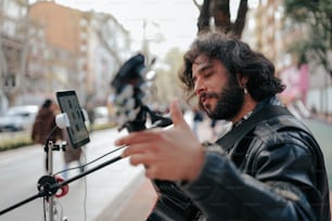 Ein Mann, der neben einer Straße steht und ein Handy in der Hand hält