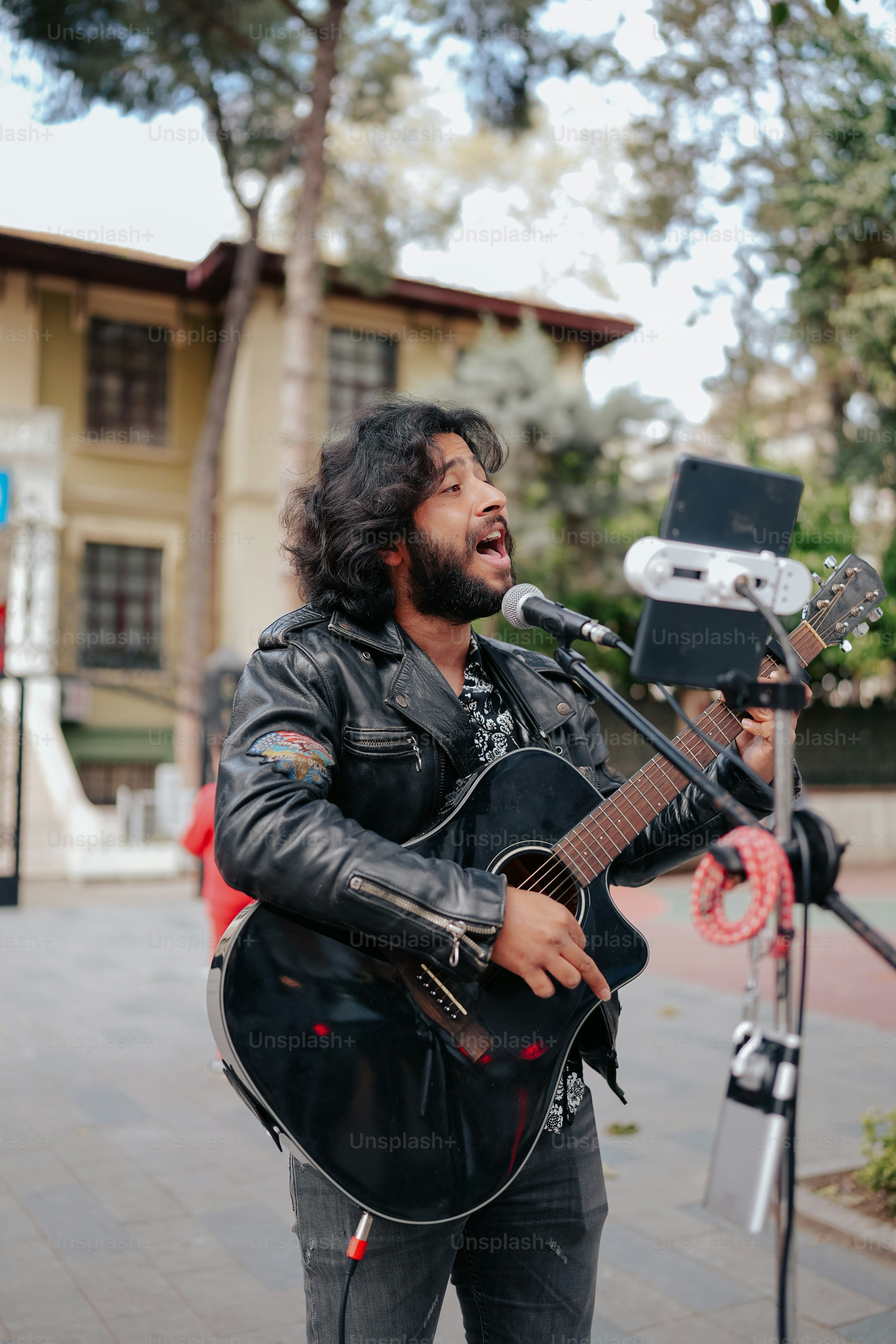 a man singing into a microphone while holding a guitar