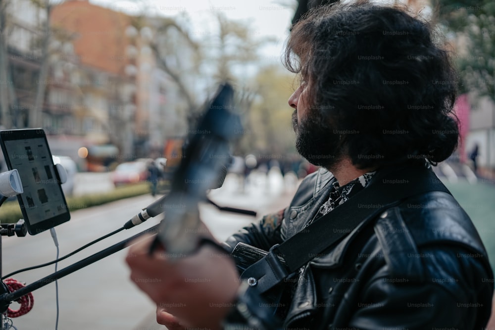 a man in a leather jacket holding a cell phone