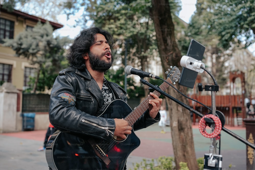 um homem tocando uma guitarra na frente de um microfone
