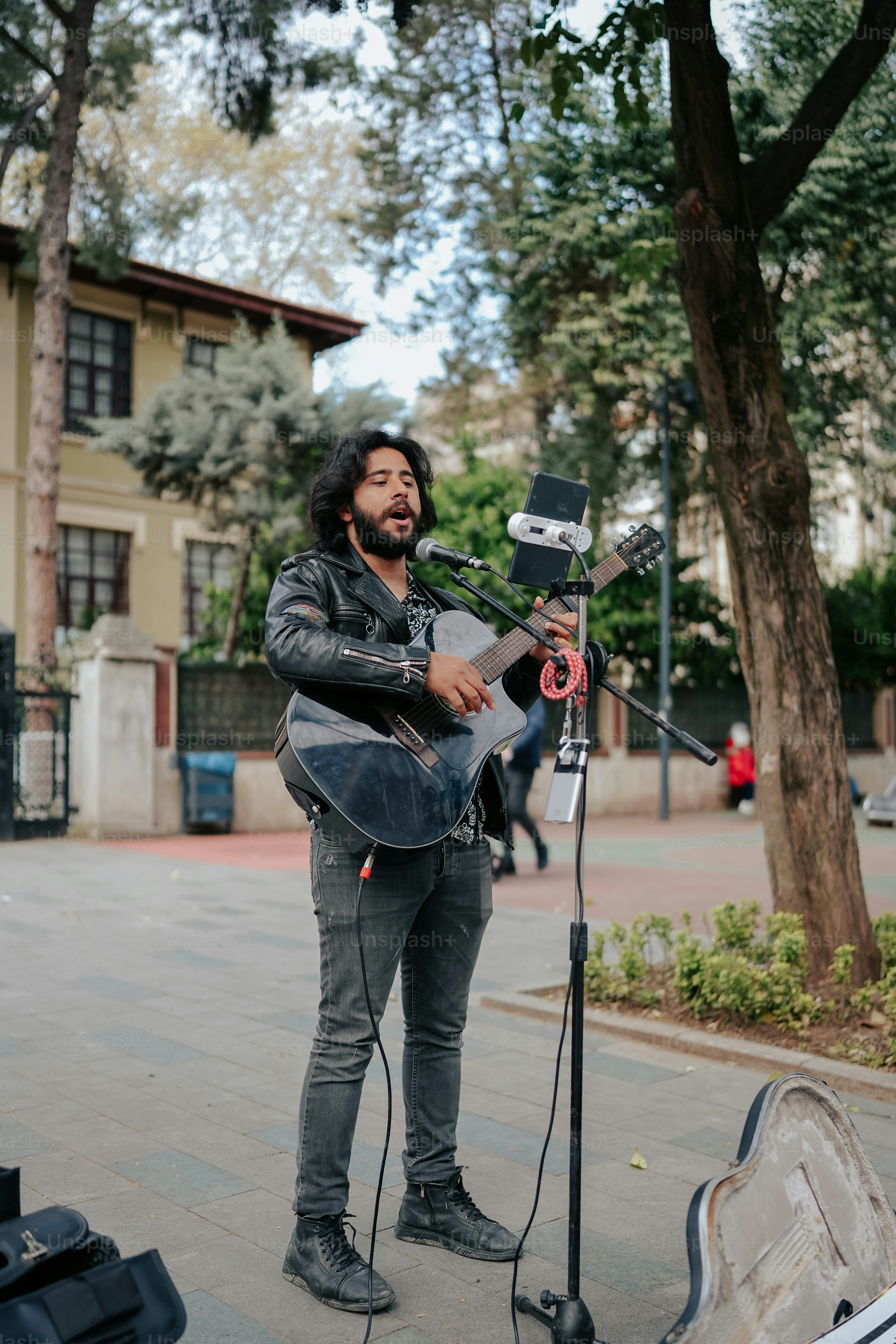 a man playing a guitar in front of a microphone
