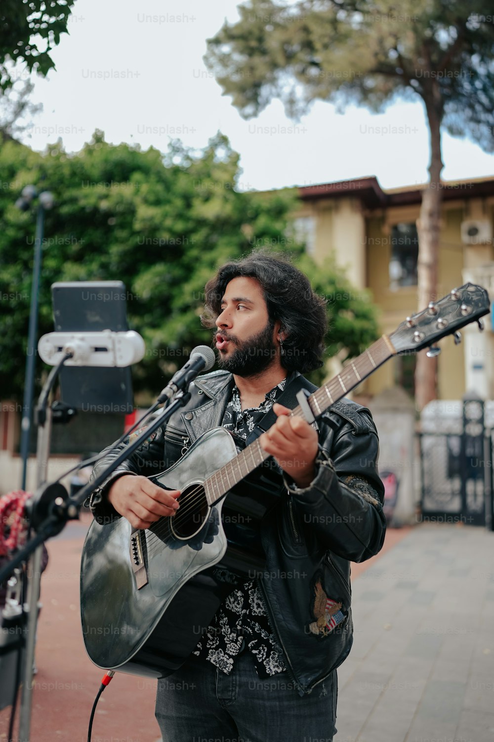 Un uomo che suona una chitarra mentre si trova su un marciapiede
