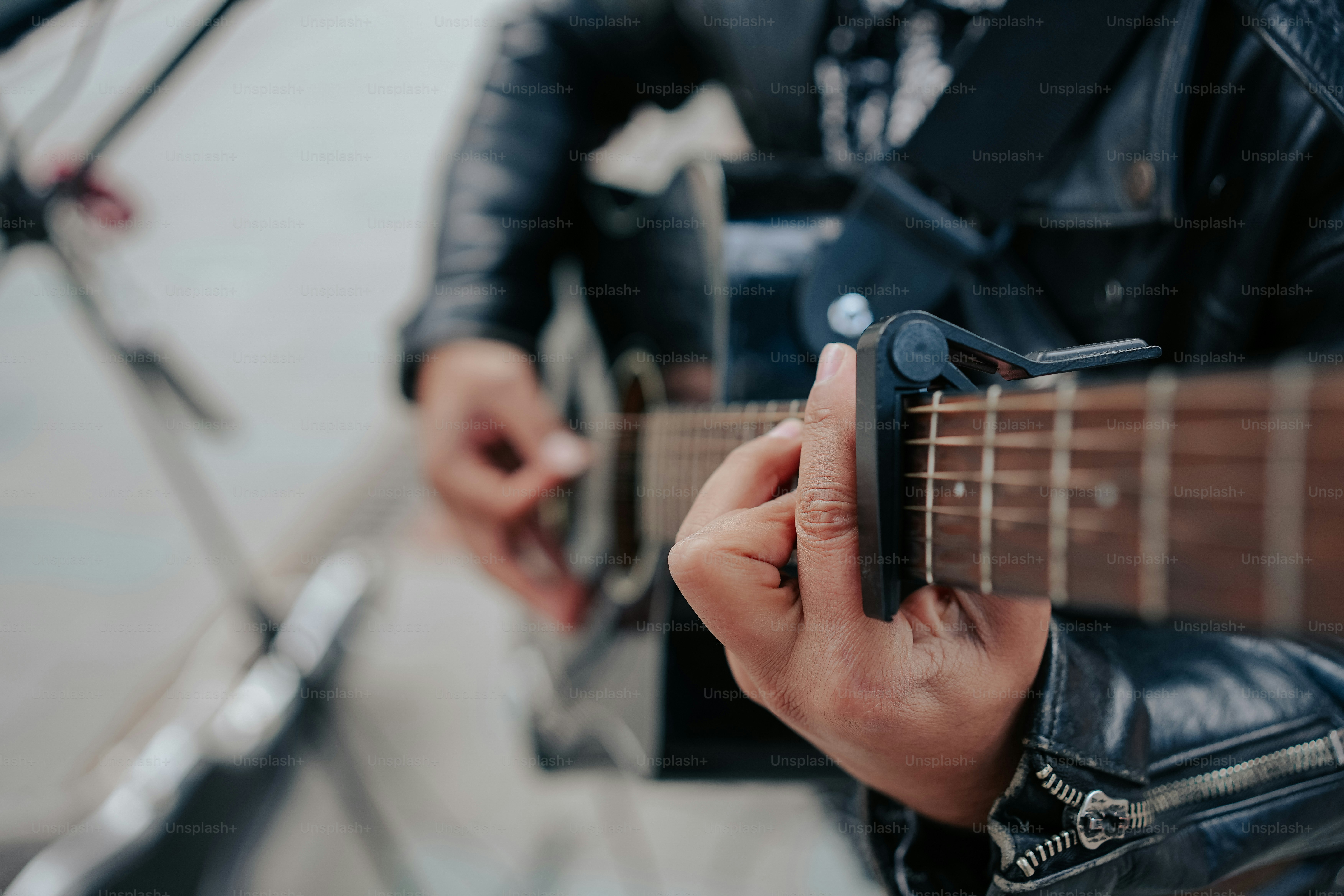 a person playing a guitar while holding a cell phone