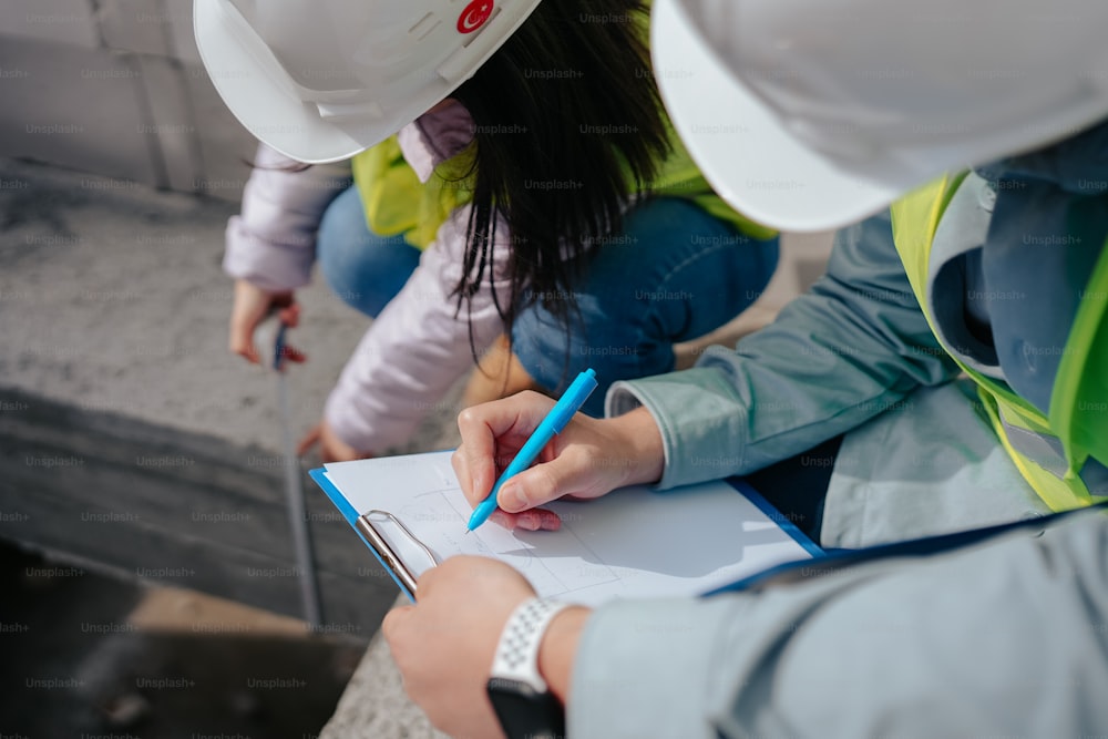 a woman in a hard hat writing on a piece of paper