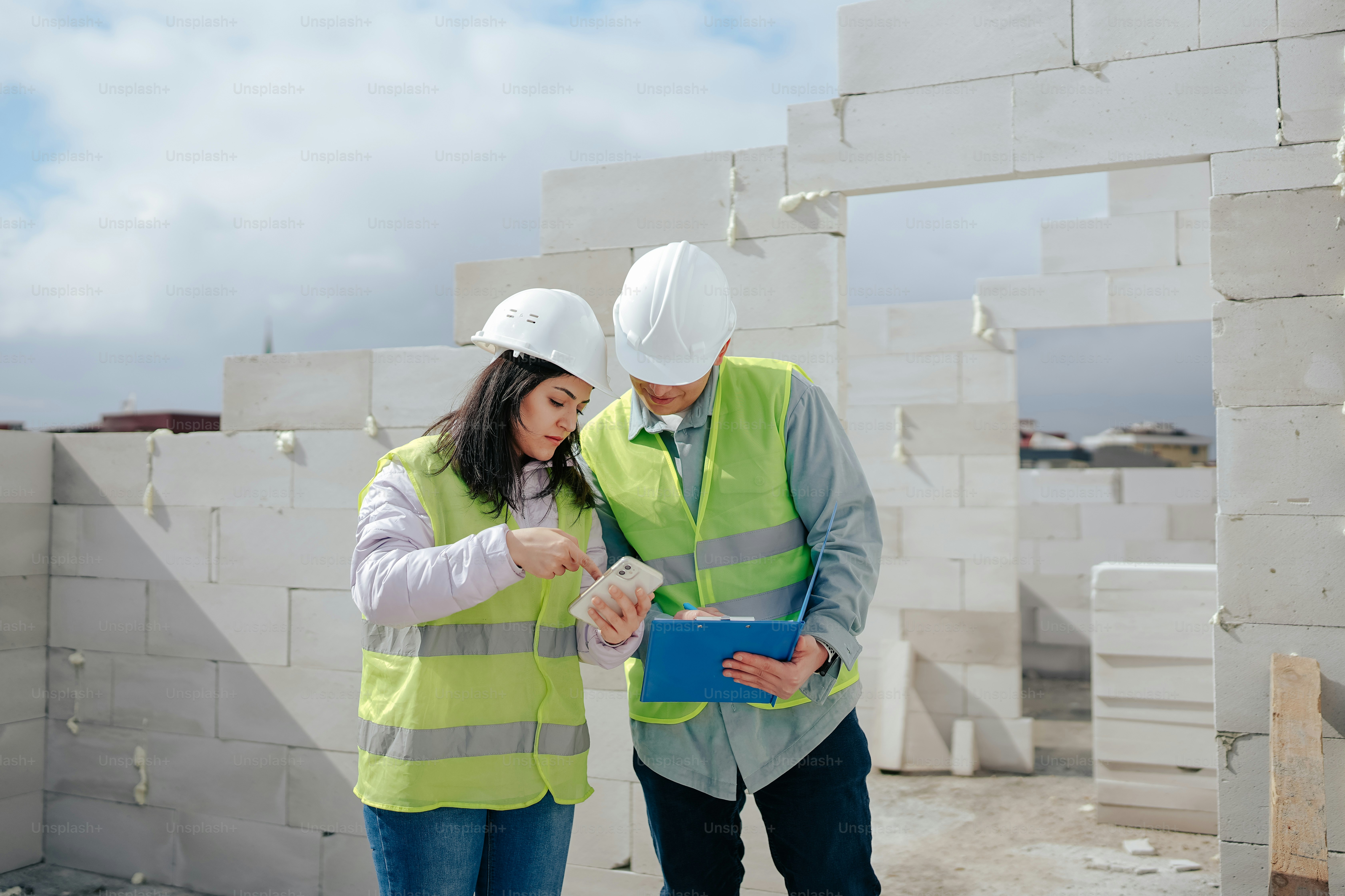 A man and a woman in hard hats and safety vests photo – Profession ...