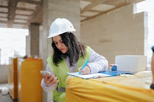 a woman in a hard hat writing on a piece of paper